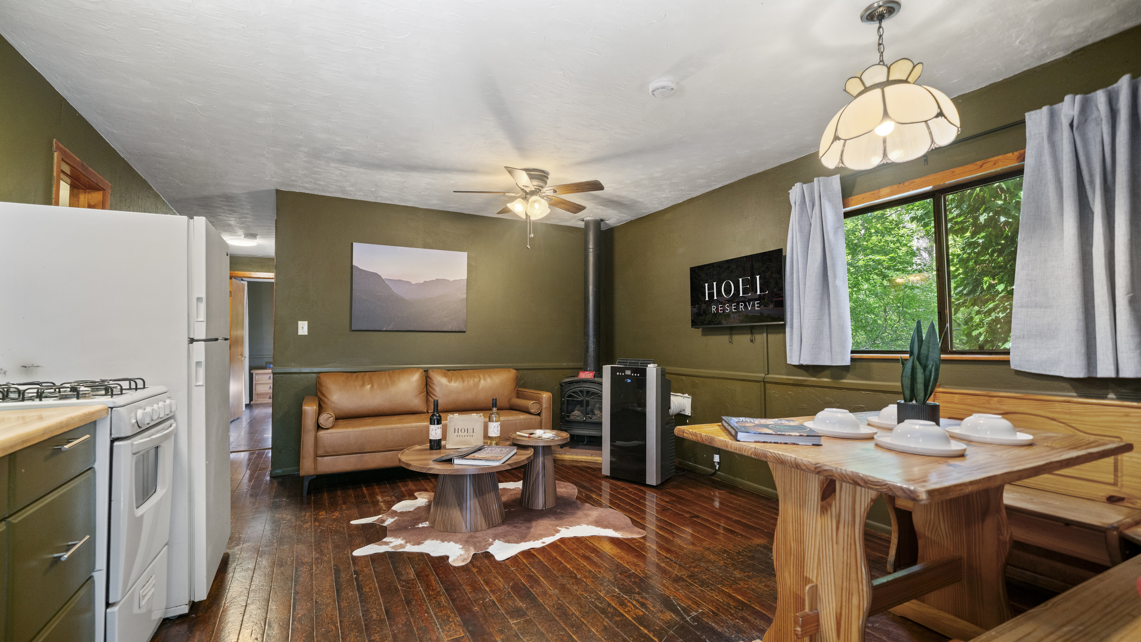 A cozy lobby with a leather sofa, wooden table, and fireplace.